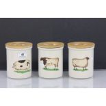 Three ceramic kitchen storage jars with wooden lids and a Farmyard animal theme, maker marked "