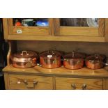 Graduating set of four Copper pans with lids and Brass handles, all with silvered interiors