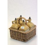 A set of four stoneware spirit flasks in original wicker basket impressed Irish Whiskey, Scotch