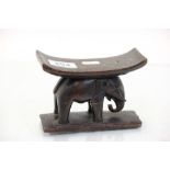 A vintage carved wooden head rest with elephant support