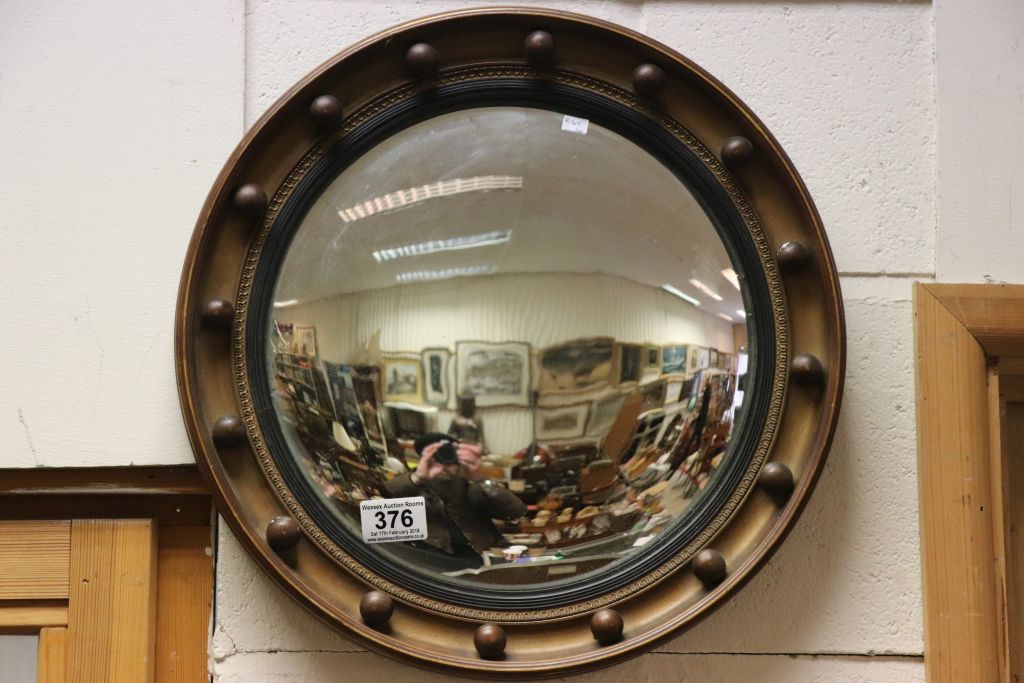 A vintage gilt circular mirror with convex looking glass