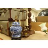 A carved wooden lamp, a lamp made from a blue and white lidded vase and a silver plated twin