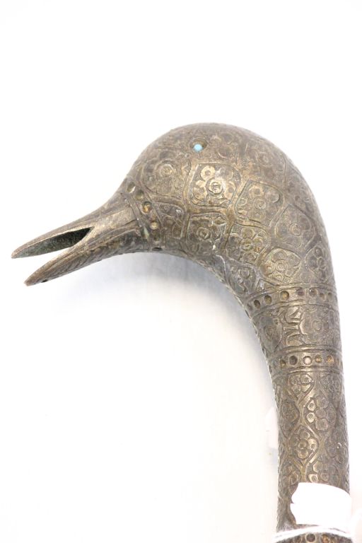 An engraved bronze walking stick handle in the form of a crane's head