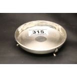 A silver circular pin dish raised on three feet, engine turned decoration, hallmarks indistinct,