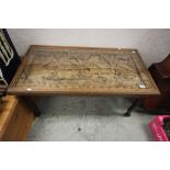 Asian Hardwood Coffee Table, the top with heavily carved relief scene of peasants in boats by