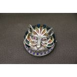 A silver plique and jour cat brooch, chased