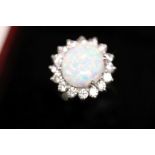 A silver CZ and opal set daisy style ring