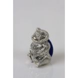 A silver pincushion in the form of a bear