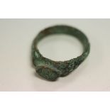 An ancient bronze ring with raised central section impressed with leaf design