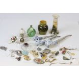 A collection of costume jewellery and ceramics to include brooches, crestedware, Devon Pottery etc