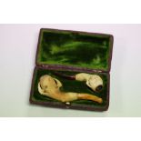 A pair of cased Meerschaum pipes in the form of claws clutching an egg with amber type mouthpieces