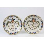 A pair of French 18th century faience plates, double heart motif with French inscription, berry