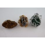 Three large statement wirework rings set with oval polished hematite, marquise shaped tigers eye and