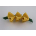 An Art Deco bakelite floral brooch, comprising three handkerchief style flowers attached to green