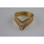 A yellow metal Arab ring, fancy wishbone, scroll openwork and faceted design, ring size N