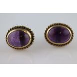 A pair of amethyst unmarked yellow gold stud earrings, the oval cabochon cut amethysts measuring