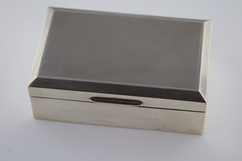 A mid 20th century silver cigarette box, Birmingham 1960, makers mark indistinct, engine turned