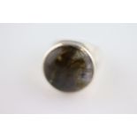 A labradorite solitaire silver ring, the large circular cabochon cut rub over set labradorite