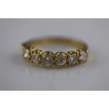 A seven stone diamond half eternity 18ct yellow gold ring, the claw set round brilliant cut diamonds