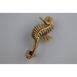 A 1960s 9ct yellow gold seahorse brooch, textured body and fins, curled tail, facing left,