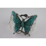 A turquoise and silver butterfly bangle, the central butterfly turquoise set measuring approximately