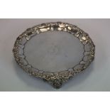 A Georgian silver salver raised on three bracket feet embossed with roses and thistles, initials