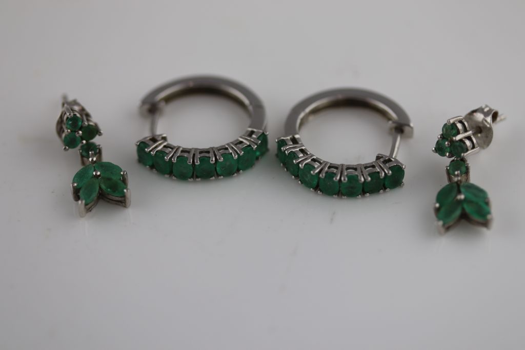 A pair of emerald silver stylised leaf drop stud earrings, marquise shaped and round mixed cut