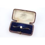 An early 20th century crossover pearl set platinum bar brooch, the circular white pearl with