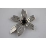 A Mexican modernist silver flower brooch, black cabochon stone rub over set to centre with five