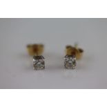 A pair of diamond solitaire 18ct yellow gold and white gold set earrings, the round brilliant cut