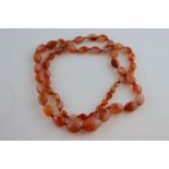 A vintage carnelian graduated bead necklace, comprising fifty-three polished oval carnelian beads,