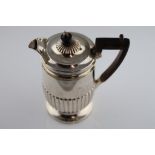 A late Victorian silver hot water pot, hinged lid, wooden finial and handle, gadrooning to lower