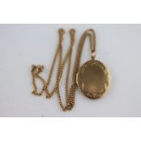 A 9ct yellow gold oval locket and chain, the oval locket with scroll detailing and geometric border,