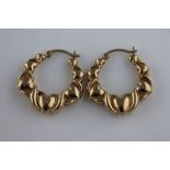 A pair of 9ct yellow gold hoop earrings, seven graduated hearts with scroll detailing to each, lever