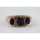 A Victorian blue sapphire graduated three stone 9ct rose gold boat head ring, closed back
