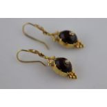 A pair of Victorian garnet and seed pearl 9ct yellow gold drop earrings, the bezel claw set centre