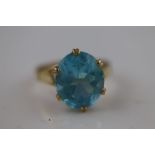 A blue topaz 18ct yellow gold ring, the claw set oval mixed cut blue topaz, measuring approximately