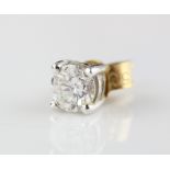 A single solitaire diamond 18ct yellow gold earring, the round brilliant cut diamond weighing