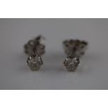 A pair of diamond solitaire white metal stud earrings, each round brilliant cut diamond weighing