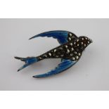 An enamelled, marcasite and paste silver swallow brooch, in flight, blue enamelled wings and tail,