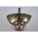 A George III silver swing handled sugar basket of navette form, repousse garland style floral and