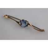 A synthetic blue spinel 9ct yellow gold bar brooch, curved scroll arms, length approximately 6cm,