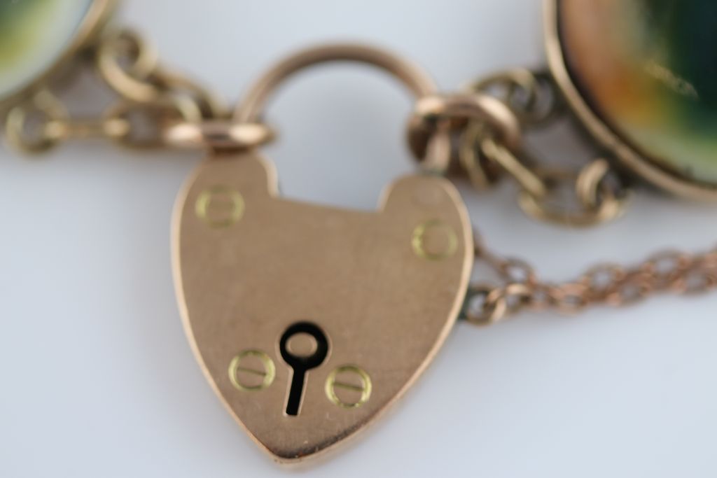 A 9ct gold charm bracelet, the 9ct rose gold padlock clasp curb link bracelet with carved - Image 8 of 8