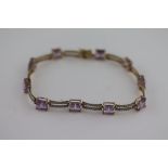 An amethyst and diamond 14ct yellow gold bracelet, ten square cut claw set amethysts measuring