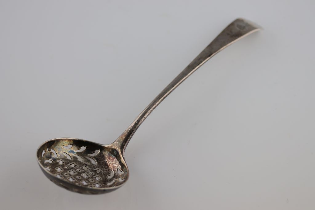 A William IV silver tea strainer, London 1835 Solomon Houghman, engraved horse head over crown crest