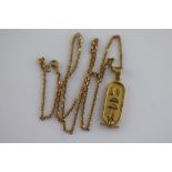 An Egyptian yellow gold pendant necklace, the tubular oval pendant with Egyptian hieroglyphics,