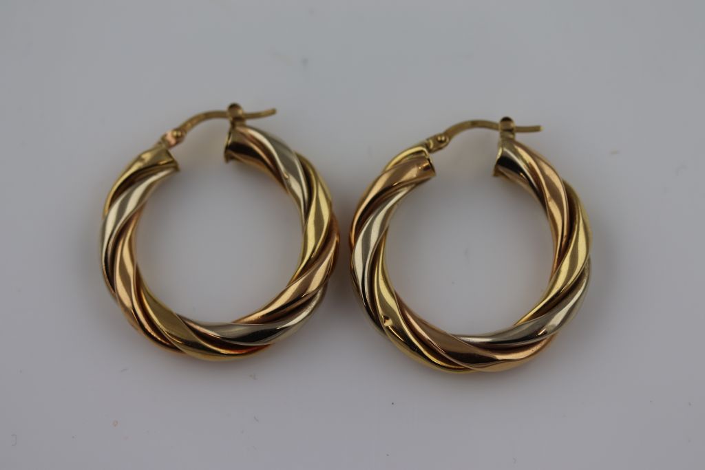 A pair of unmarked gold twisted hoop earrings, subtle tri-colour gold finish, diameter