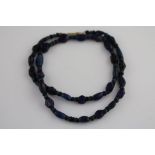 A string of antique blue glass beads, alternate oval and faceted navy blue glass beads with circular