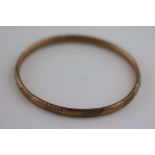 A 9ct rose gold bangle, textured engraved decoration, band width approximately 5mm