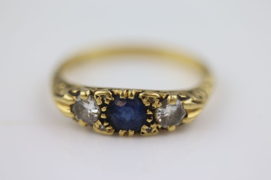 A Victorian style blue sapphire and diamond 18ct yellow gold three stone boat head ring, the central